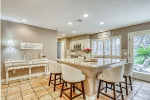 a kitchen with a large island with chairs around it at Chic Poolside Paradise in San Antonio