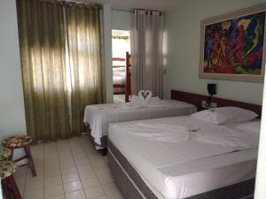 2 bedden in een hotelkamer met een raam bij Apart Service Araras - VPC in Caldas Novas