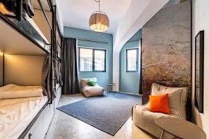 um quarto com paredes azuis e um sofá e uma mesa em Athens Hub Hostel em Atenas