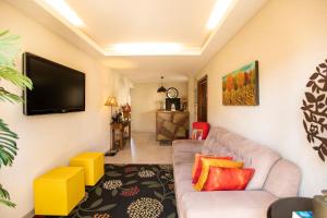 a living room with a couch and a flat screen tv at Pousada do Frei in Búzios