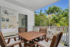 a dining room with a table and chairs on a balcony at Seascape Holidays at The Queenslander in Port Douglas
