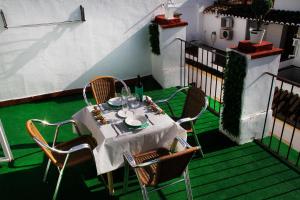コルドバにあるViviendas Turísticas La Luna Aticoのバルコニーに白いテーブルクロス付きのテーブル