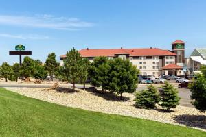 a hotel with trees in front of a parking lot at La Quinta Inn and Suites by Wyndham at WaTiki Waterpark in Rapid City