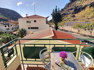 a balcony with a table and a vase of flowers at Sea N' Sun Apartment by LovelyStay in Ribeira Brava