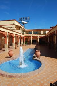 a fountain in a courtyard in front of a building at Hotel Trajano in Zalamea de la Serena