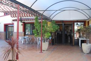 Zalamea de la SerenaにあるHotel Trajanoのテーブルと椅子付きのオープンパティオのあるレストランを併設しています。