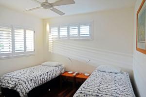 two beds in a room with two windows at At Cylinder Unit 3 in Point Lookout