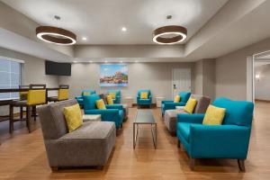 a waiting room with blue furniture and a piano at La Quinta Inn and Suites by Wyndham at WaTiki Waterpark in Rapid City
