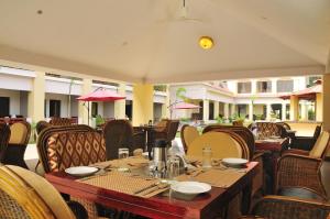 a restaurant with a wooden table and chairs at Le Roi Corbett in Garjia