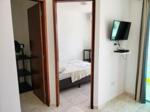 a room with a mirror and a bed and a television at Flats Parada Obrigatoria in Maragogi
