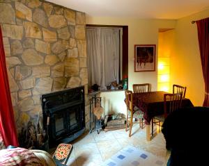 a living room with a table and a stone fireplace at Casa Dono Sanabria in Cobreros