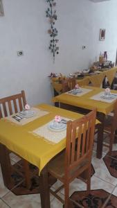 uma mesa amarela com cadeiras e uma toalha de mesa amarela em Pousada Bruluka em Tiradentes