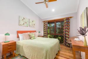 a bedroom with a bed and a window at Friday Creek Retreat in Coffs Harbour