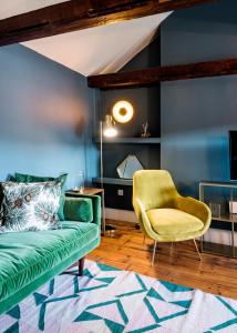 a living room with a green couch and a yellow chair at ARCORE Premium Rental Grafton Way in London