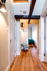 einen Flur mit Holzböden und einer Decke mit Balken in der Unterkunft ARCORE Premium Rental Grafton Way in London