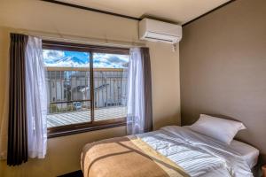 a bedroom with a bed and a window with a balcony at ID-STAY河口湖Ⅲ in Fujikawaguchiko