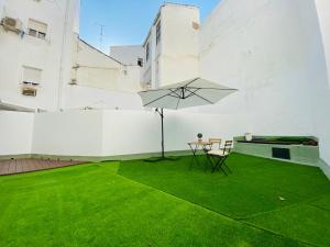 a patio with a table and an umbrella at CLB F. Rubio Apartment in Seville