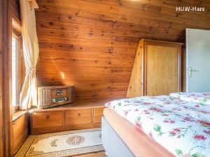 een slaapkamer met een bed en een houten wand bij Finnhütte am Kapitelsberg in Wernigerode