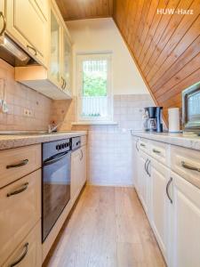 een keuken met witte apparatuur en een houten plafond bij Finnhütte am Kapitelsberg in Wernigerode