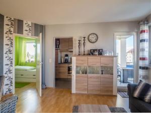 uma sala de estar com uma cozinha com um relógio na parede em Ferienwohnung Münster em Wernigerode