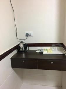 a black dresser with a lamp on top of it at Hang Ho Hostel in Hong Kong