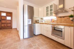 a kitchen with white cabinets and a stainless steel refrigerator at Villa Polonijo in Vrh
