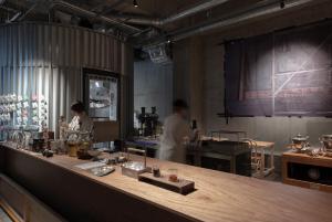 dos hombres en una cocina preparando comida en TSUGU Kyoto Sanjo by THE SHARE HOTELS, en Kioto