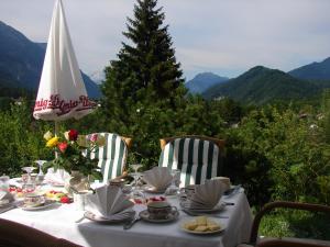 uma mesa com uma toalha de mesa branca e cadeiras e uma árvore em Tonihof Eschenlohe em Eschenlohe