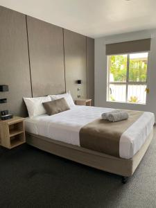 Un dormitorio con una cama grande y una ventana en Huskisson Beach Motel en Huskisson