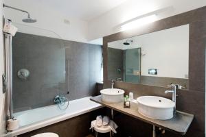 a bathroom with a sink and a tub and a mirror at Hotel La Badia di Orvieto in Orvieto