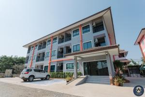 a white car parked in front of a building at Thepchamrat Boutique Hotel in Uttaradit