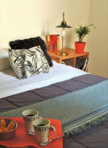 1 dormitorio con 1 cama con 2 tazas en una bandeja en Stylish duplex in Caseros Boulevard - San Telmo en Buenos Aires