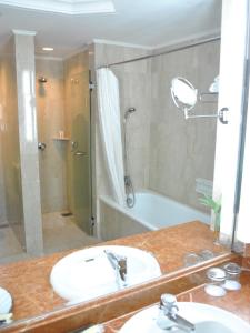 a bathroom with a sink and a shower and a tub at Le Grandeur Palm Resort Johor in Kulai