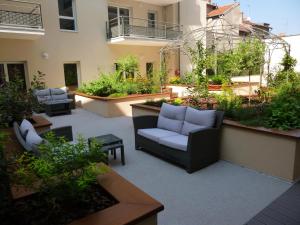 un patio con mobili e piante in un edificio di La Résidence Therm’Appart a Vichy