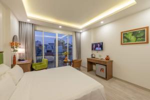 a bedroom with a large white bed and a desk at AMI Old Quarter Hotel in Hanoi