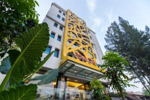 a building with a yellow and white facade at Royal City Hotel in Jakarta