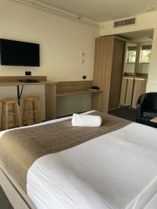 a hotel room with a bed and a flat screen tv at Huskisson Beach Motel in Huskisson