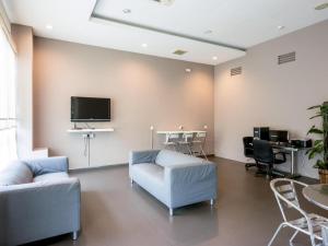 Raintree Hotel في كوالالمبور: غرفة معيشة مع أريكة وتلفزيون على الحائط