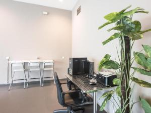 an office with a desk with a computer and a plant at Raintree Hotel in Kuala Lumpur