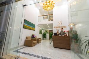 a lobby of a clinic with two people sitting at a counter at AMI Old Quarter Hotel in Hanoi