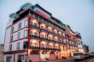 Un gran edificio rojo y blanco en una calle de la ciudad. en Green Rose Hotel, en Batam Centre