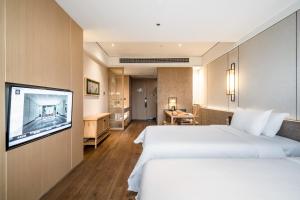 a hotel room with two beds and a television at The Hidden House Cheng Du Du Fu Thatched Cottàge Branch in Chengdu