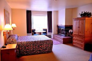 um quarto de hotel com uma cama e uma lareira em Pacific Gardens Inn em Pacific Grove