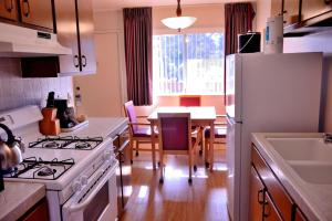 uma cozinha com um fogão branco forno superior ao lado de uma mesa em Pacific Gardens Inn em Pacific Grove