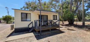 a small house with a porch on the side of it at Pinjarra Caravan Park and Cabins in Pinjarra