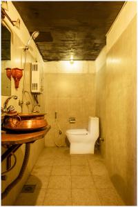 a bathroom with a sink and a toilet in a room at Hira Guest House in Pātan