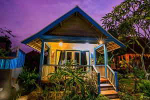 una casa pequeña con techo azul y escaleras en Nanuk's Bungalows, en Nusa Lembongan