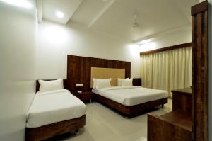 1 dormitorio con 2 camas y ventana. en HOTEL DWARKA PARK en Shirdi