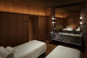 a bathroom with two beds and a sink and a mirror at Park Hyatt Kyoto in Kyoto