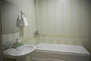 a bathroom with a bath tub and a sink at Hotel Minor in Samarkand
